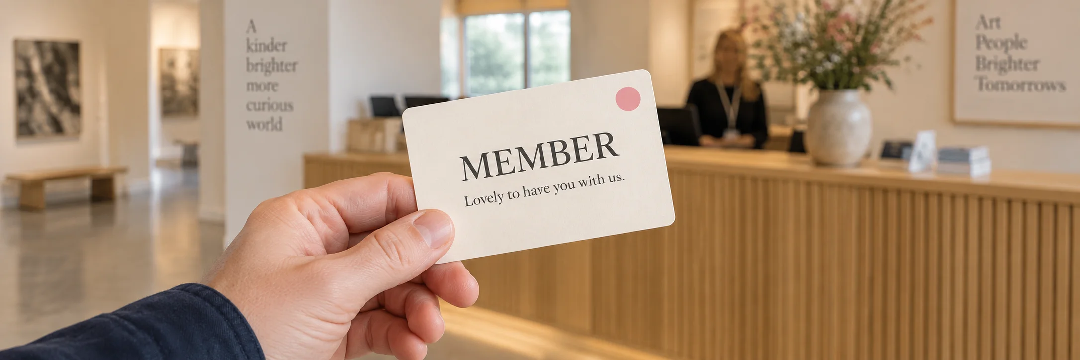 A supporter holding a membership card at a welcoming gallery reception.